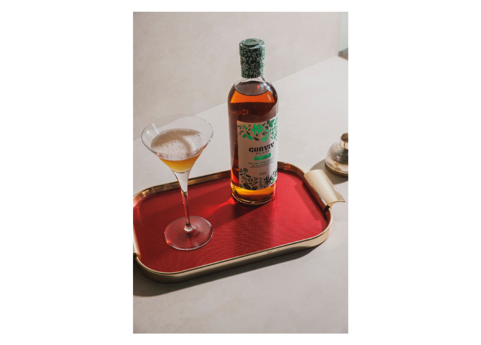 Een vintage dienblad met een fles Conviv Bianco en een martiniglas met schuim